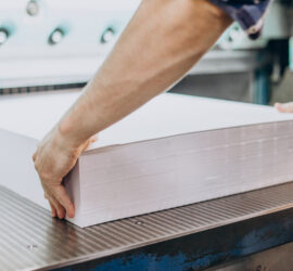 Man working in printing house with paper and paints